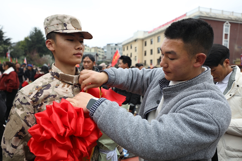 家屬為即將踏上征途的新兵整理光榮花 陳春志 攝