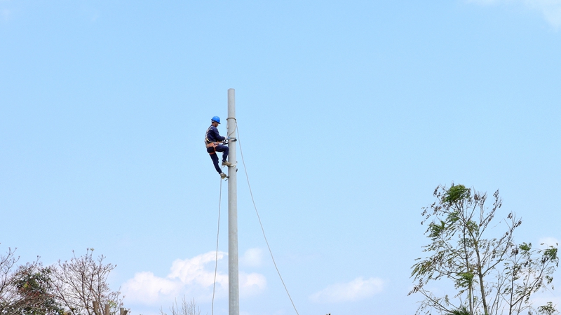 電桿立好后工作人員上桿解繩索.jpg