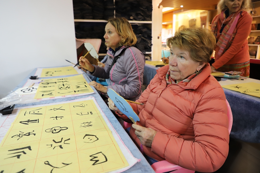 外國(guó)游客沉浸式打卡貴州三都水族非遺。