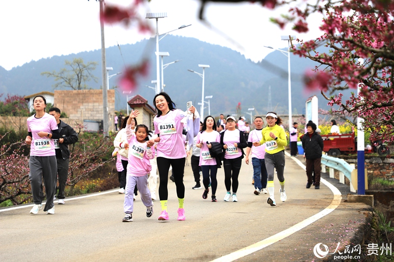 親子選手在桃林賽道奔跑，感受鄉野生機。人民網 龍章榆 攝