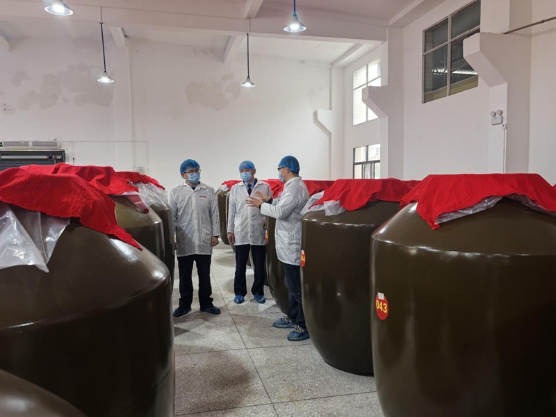 (圖六 納稅人向稅務干部講解魚醬酸裝壇發酵原理)