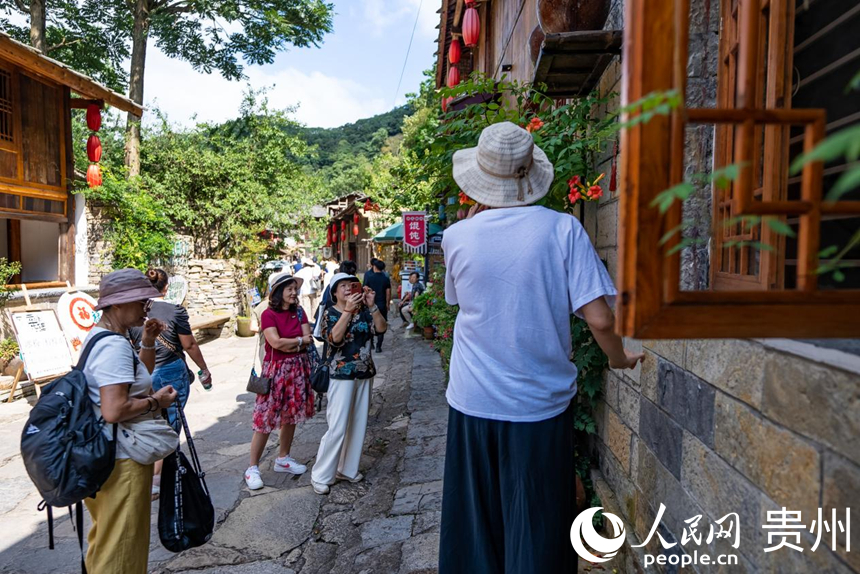 游客在屯堡內(nèi)打卡拍照。人民網(wǎng)記者 涂敏攝