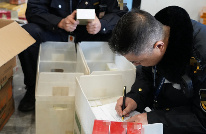 查案現(xiàn)場清點(diǎn)涉案卷煙。陳偉攝.jpg