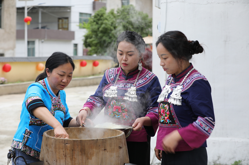 布依婦女正在蒸煮糯米。