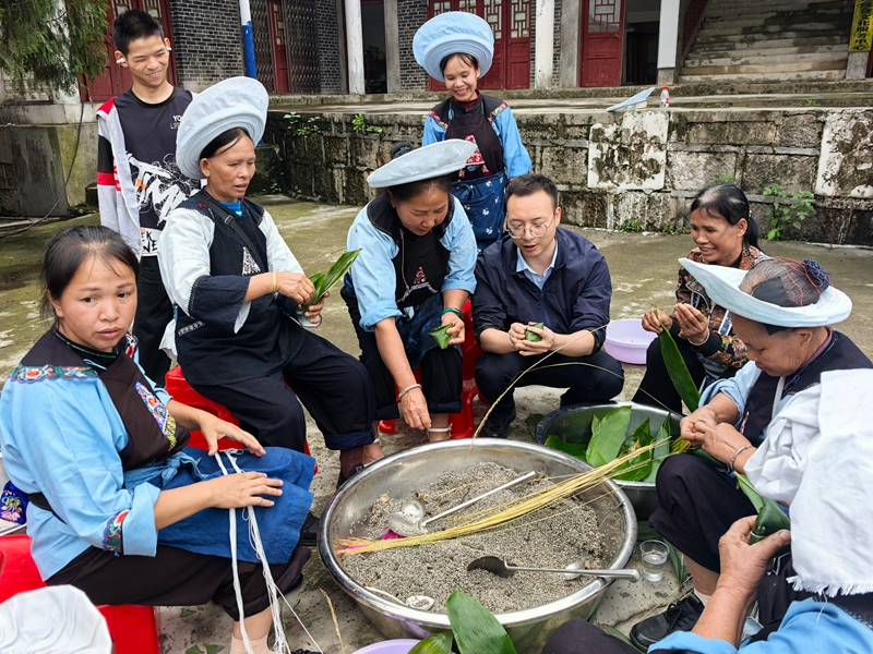 貴州大學靳志華老師和少數民族群眾一起體驗民族習俗。