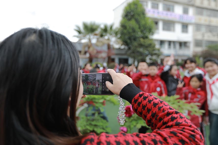 2026年3月31日，貴州省黔西市第一小學(xué)的老師和學(xué)生在校園里欣賞牡丹花，并拍照留影。