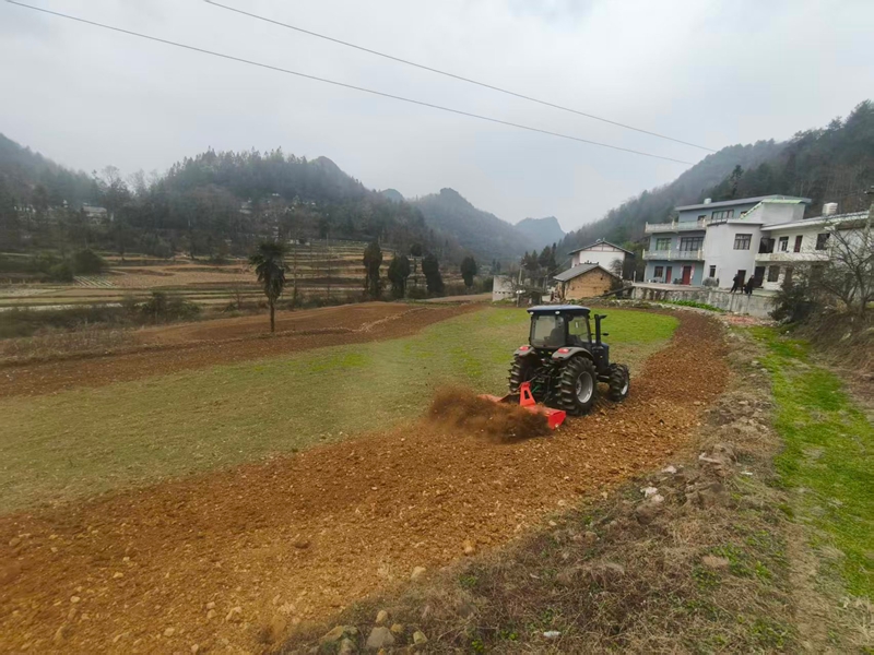 農機手正在駕駛農耕機翻耕土地。