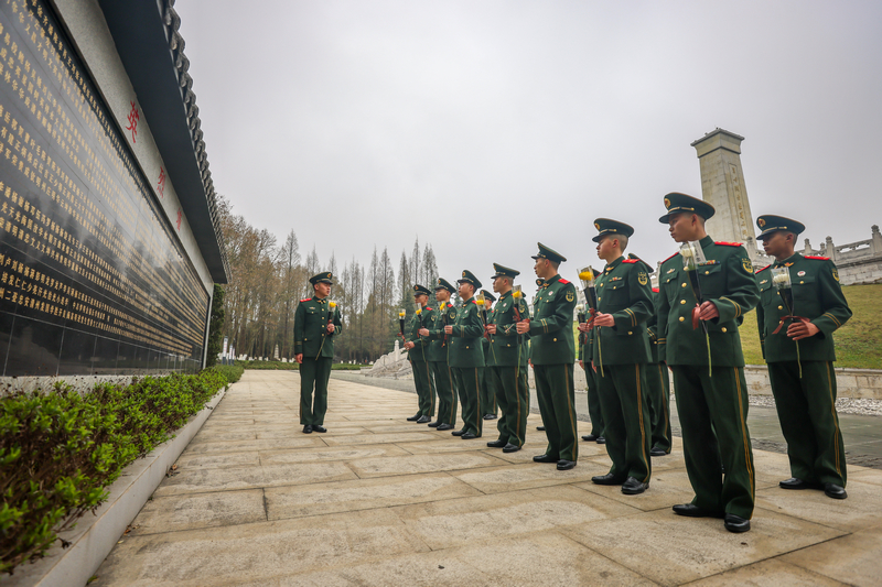 該支隊官兵在烈士英名墻下講述英烈的感人事跡。
