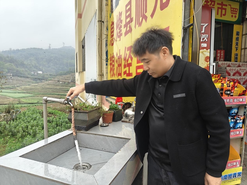 村民打開水龍頭展示水量水質情況.jpg