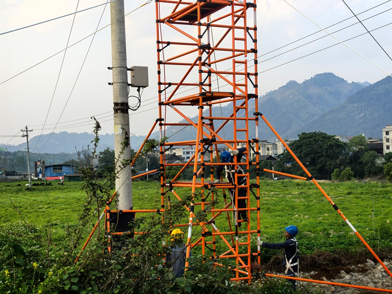 在貴州省黔東南苗族侗族自治州榕江縣忠誠鎮10千伏忠工Ⅱ線福工聯絡線1號桿處，南方電網貴州凱里榕江供電局工作人員首次采用絕緣平臺開展帶電作業工作。圖為正在搭建平臺中（胡乾 攝）1.jpg