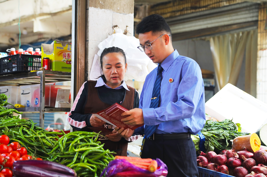 4月13日,施秉檢察干警在農貿市場給群眾講解國家安全相關法律宣傳知識。吳桂花攝